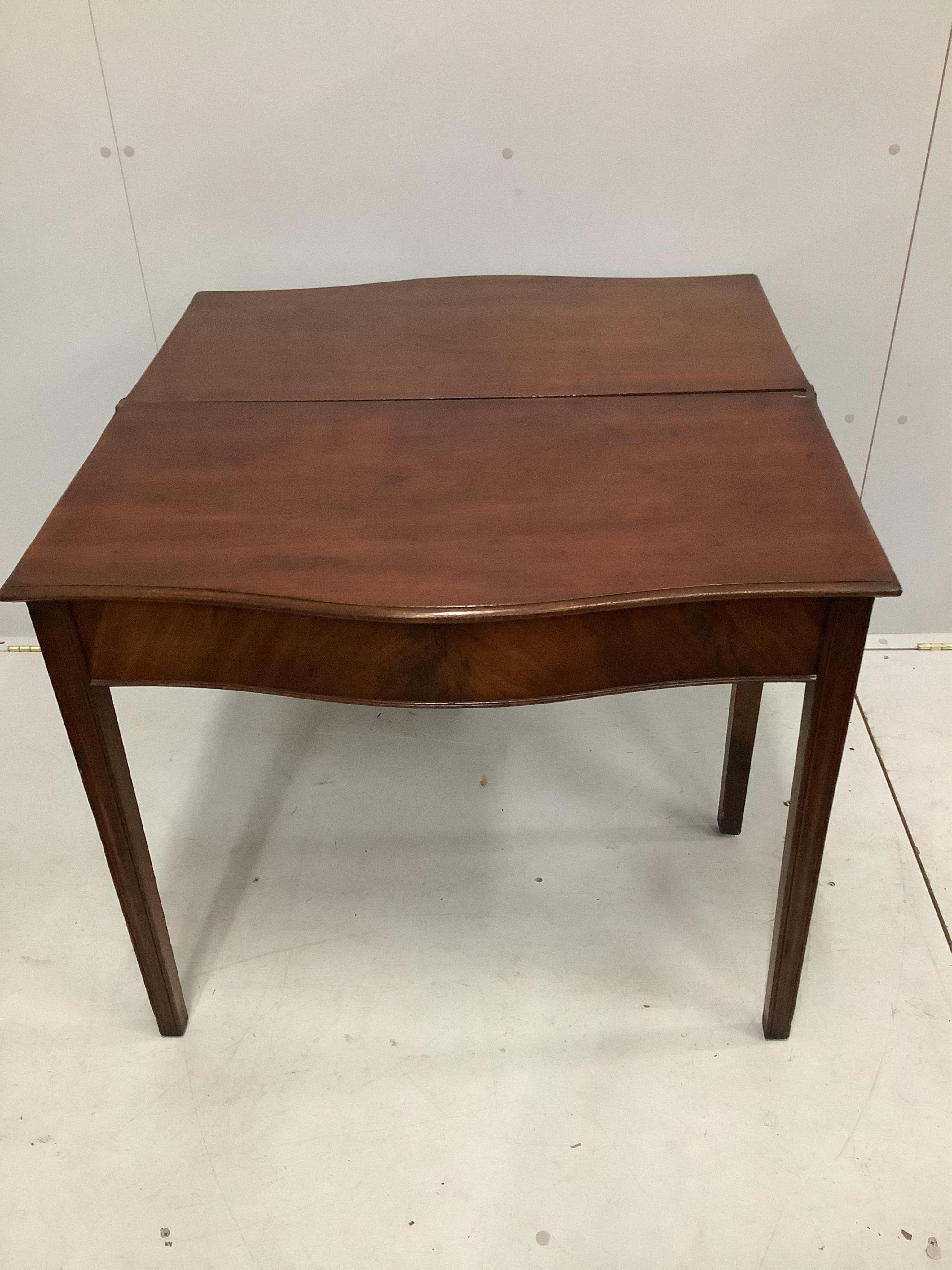 A George III mahogany serpentine fronted folding tea table, width 86cm, depth 46cm, height 75cm. Condition - fair